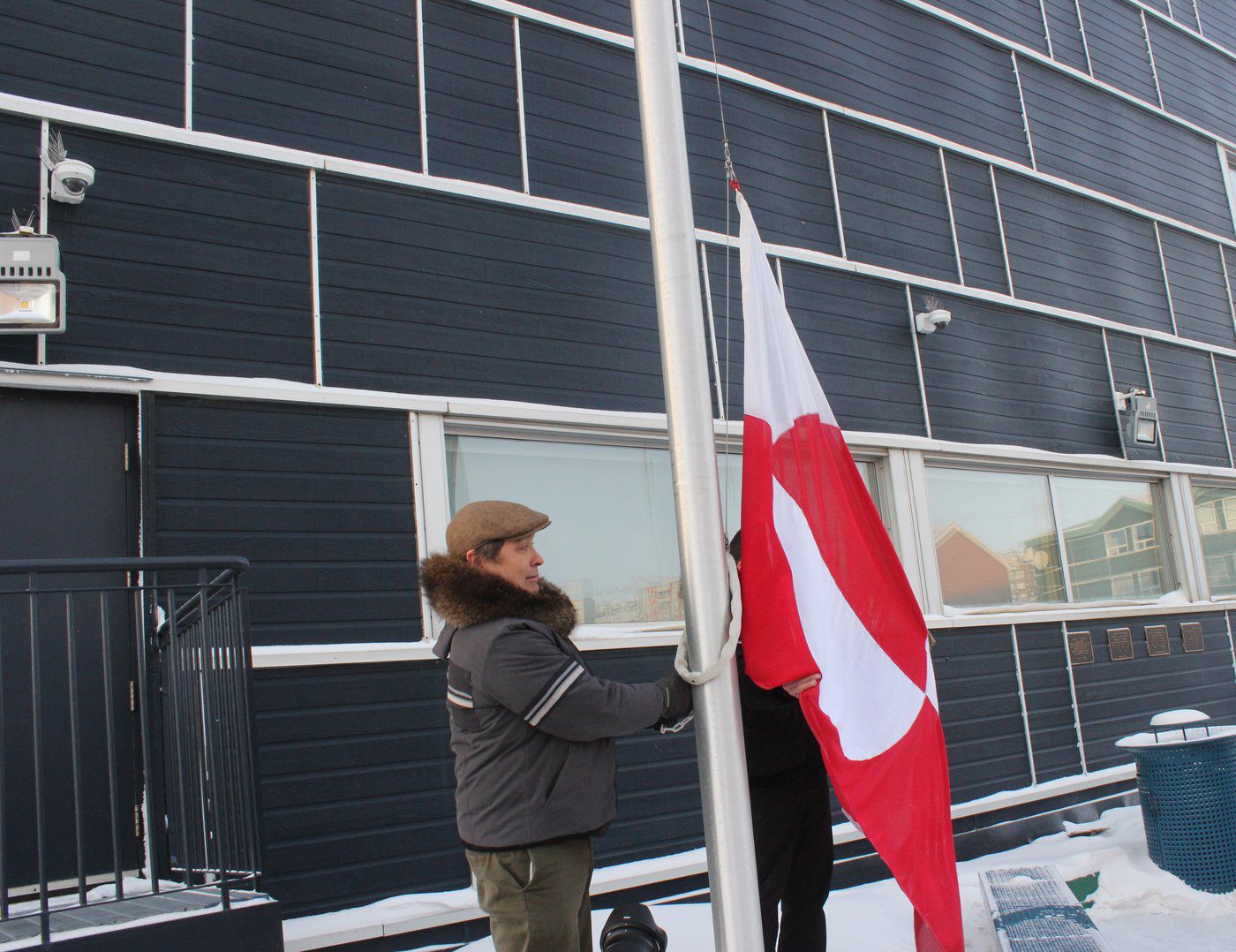 Speaker of the Nunavut Legislative Assembly David Joanasie raises the Greendlandic flag at the territorial legislature on Jan. 20. William Koblensky Varela/NNSL photo